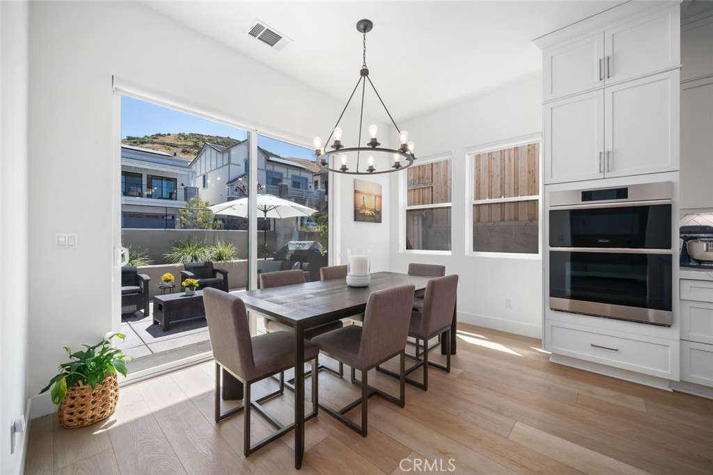 4019 Hillside Drive San Luis Obispo, CA 93401 - Photo 12 of 32 a dining room with furniture a chandelier and wooden floor