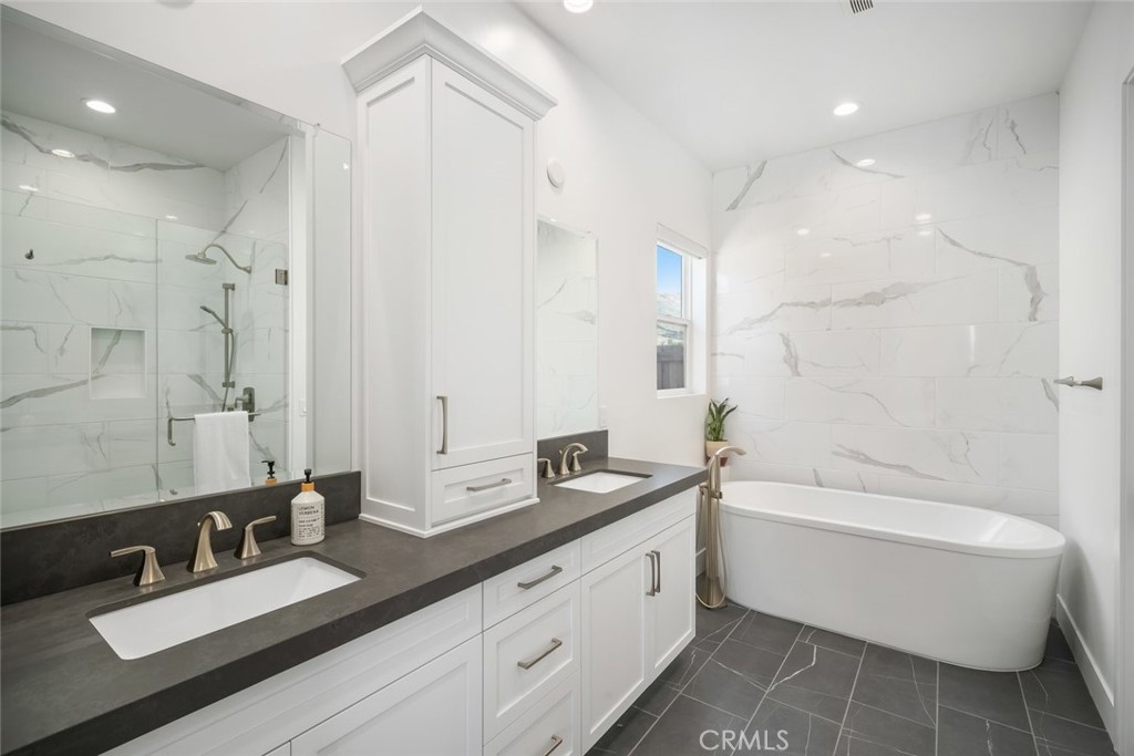 4019 Hillside Drive San Luis Obispo, CA 93401 - Photo 15 of 32 a bathroom with a double vanity sink large mirror and a bathtub