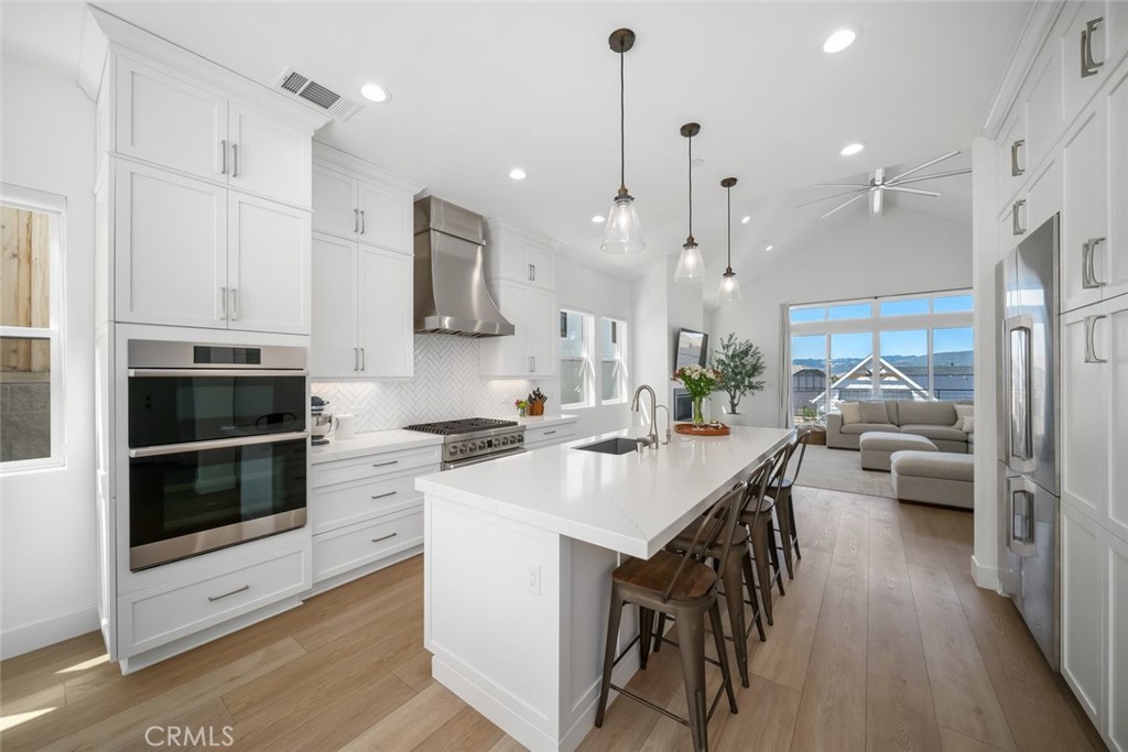 4019 Hillside Drive San Luis Obispo, CA 93401 - Photo 3 of 32 a kitchen with stainless steel appliances kitchen island granite countertop a stove a sink a oven and a refrigerator with wooden floor