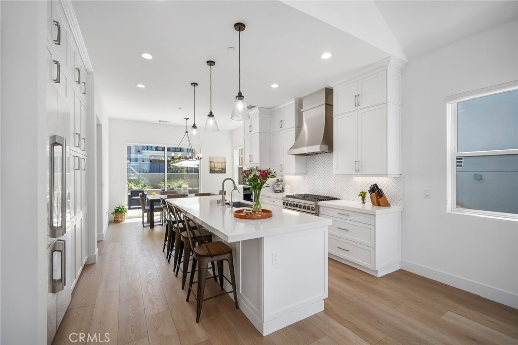 4019 Hillside Drive San Luis Obispo, CA 93401 - Photo 10 of 32 a kitchen view with stainless steel appliances kitchen island granite countertop a refrigerator a stove a dining table and chairs with wooden floor