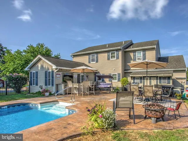 a front view of a house with swimming pool having outdoor seating