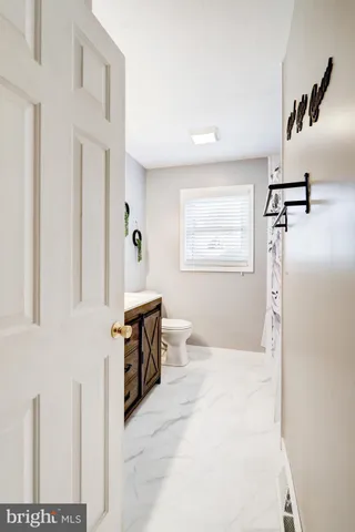 a bathroom with a granite countertop sink a toilet and a mirror