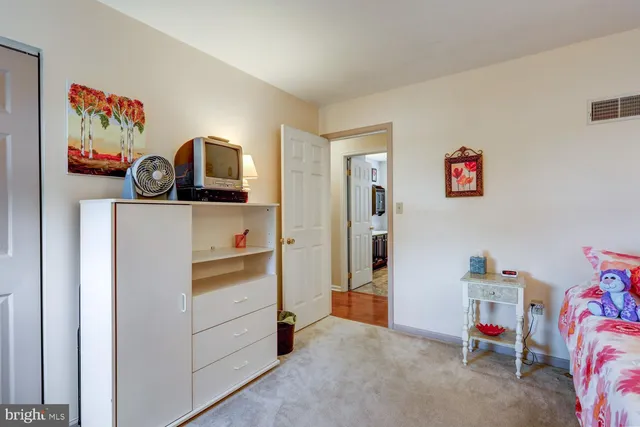 a view of a bedroom with baby bed and workspace