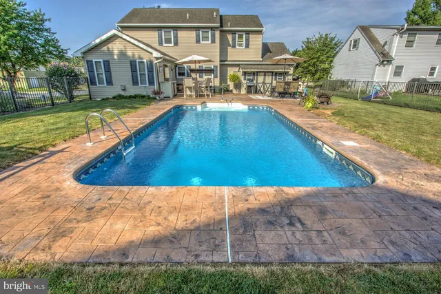 a view of a house with swimming pool and sitting area