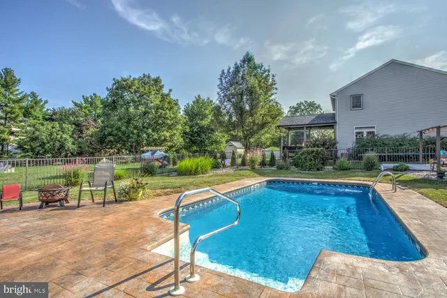a patio with a table and chairs and potted plants