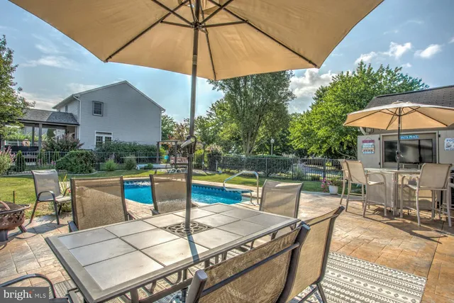 a patio with a table and chairs under an umbrella