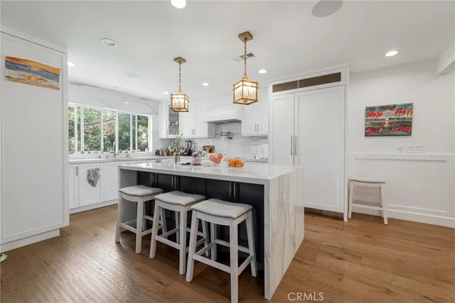 a kitchen with a dining table chairs cabinets and stainless steel appliances