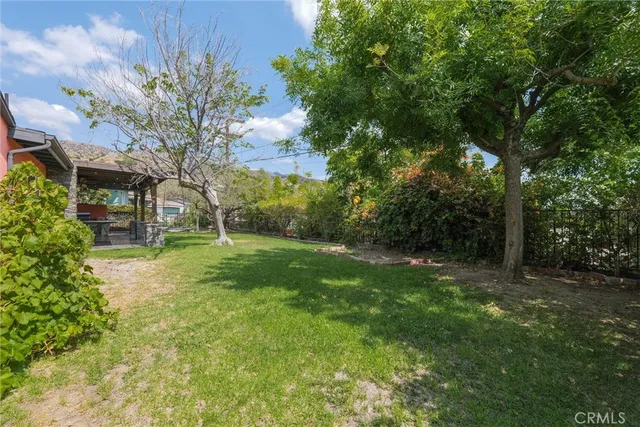 a view of a chair and table in backyard of the house