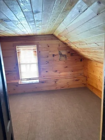 a view of an empty room with furniture and a window