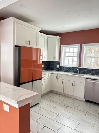 a kitchen with granite countertop a sink and white cabinets