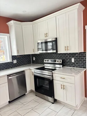 a kitchen with granite countertop white cabinets and white appliances