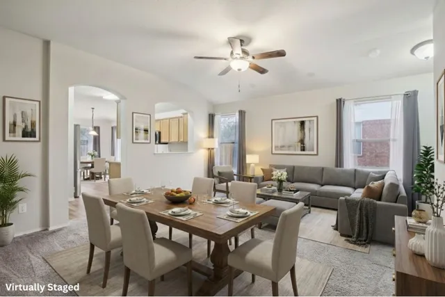 a living room with furniture kitchen view and a window
