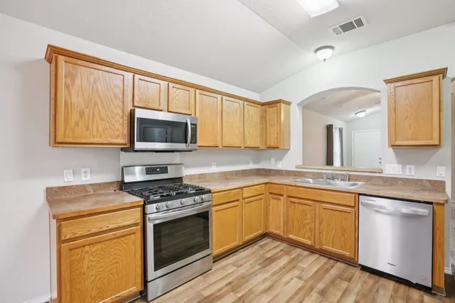 a kitchen with a sink stove top oven and microwave