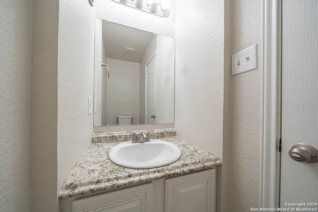 a bathroom with a granite countertop sink and a mirror