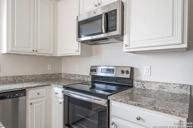 a kitchen with stainless steel appliances granite countertop a sink stove and microwave