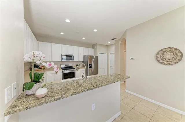 a kitchen with a sink cabinets stainless steel appliances and a window