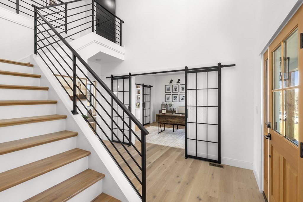 6 Woodman Road Amesbury, MA 01913 - Photo 4 of 37 a view of staircase with lots of frames on wall and a window