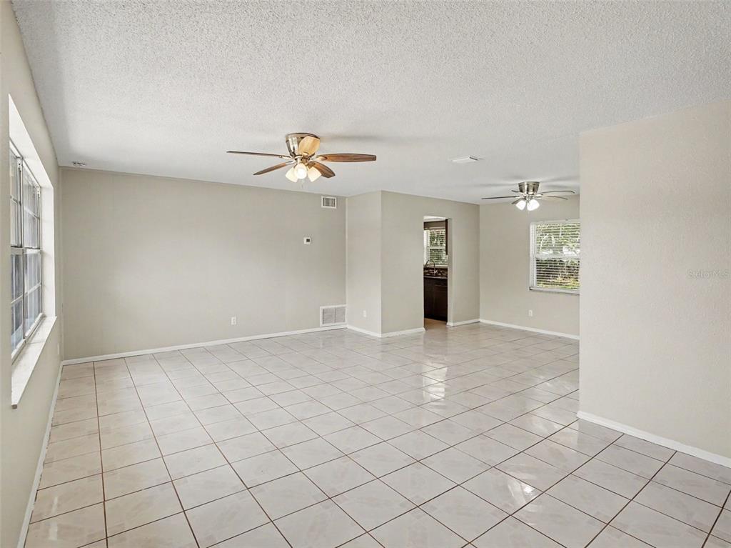 615 Thomas Jefferson Way Orlando, FL 32809 - Photo 7 of 17 an empty room with windows and chandelier fan