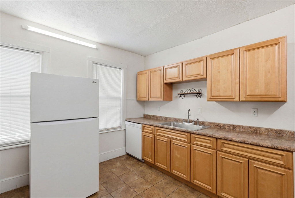 22 Deering Road, Unit 1 Boston, MA 02126 - Photo 4 of 12 a kitchen with a sink a refrigerator and cabinets
