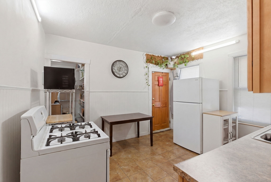 22 Deering Road, Unit 1 Boston, MA 02126 - Photo 5 of 12 a kitchen with a refrigerator and a stove top oven