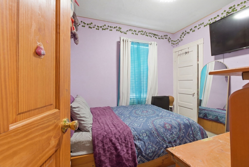 22 Deering Road, Unit 1 Boston, MA 02126 - Photo 8 of 12 a bedroom with a bed window and flat screen tv