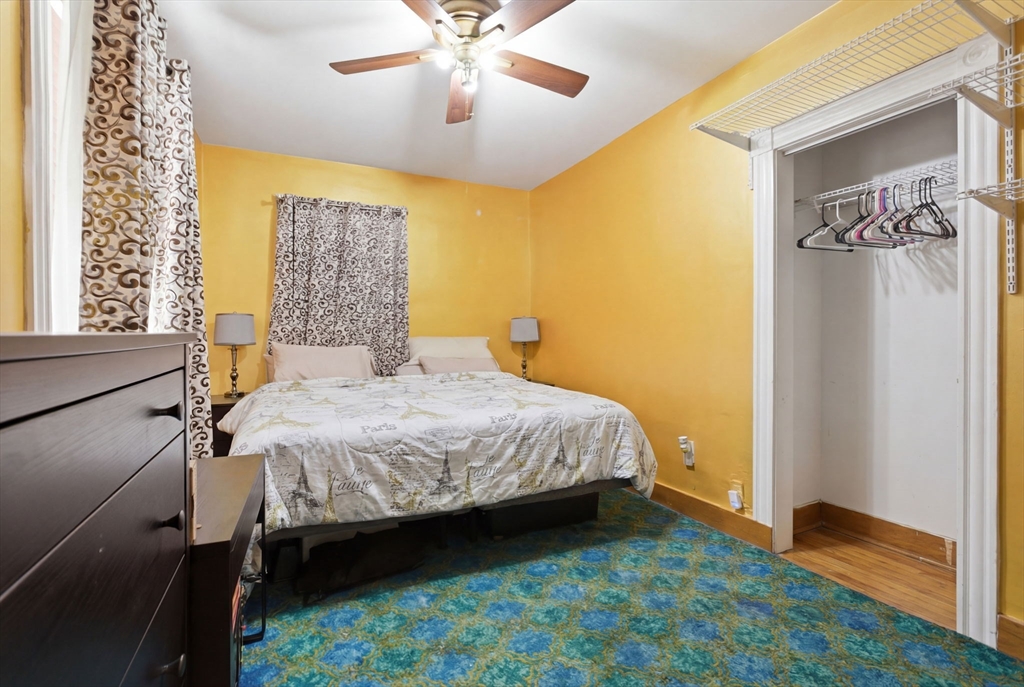 22 Deering Road, Unit 1 Boston, MA 02126 - Photo 9 of 12 a bedroom with a bed and a chandelier