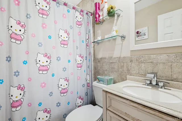 a bathroom with a sink a toilet and a curtain