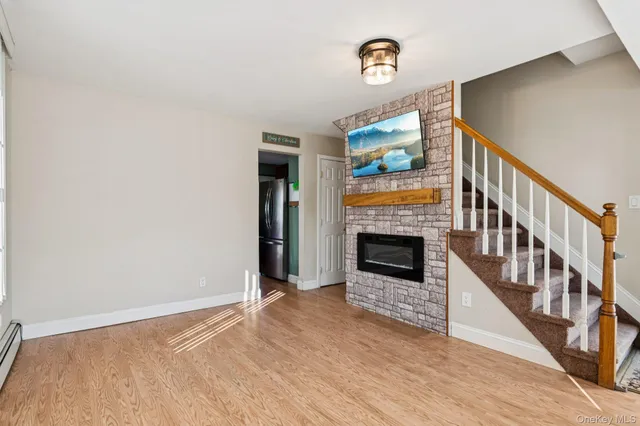 a view of a livingroom with wooden floor and a fireplace