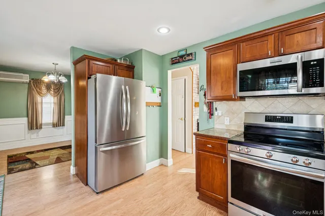 a kitchen with granite countertop a refrigerator stove and microwave