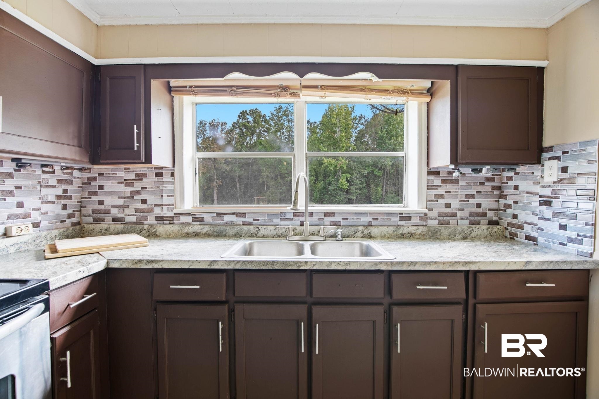 23240 County Road 47 Perdido, AL 36562 - Photo 18 of 29 Kitchen featuring dark brown cabinetry, light countertops, backsplash, plenty of natural light, and crown molding