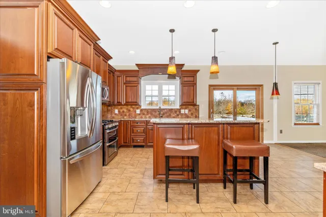 a kitchen with stainless steel appliances granite countertop a stove a sink and a refrigerator