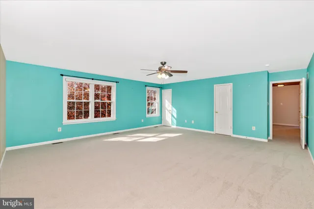 a view of an empty room with a ceiling fan