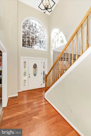 a view of staircase with lots of frames on wall and wooden floor