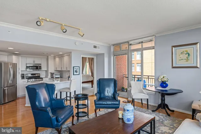 a living room with furniture kitchen view and a window
