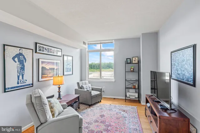 a living room with furniture a flat screen tv and a window