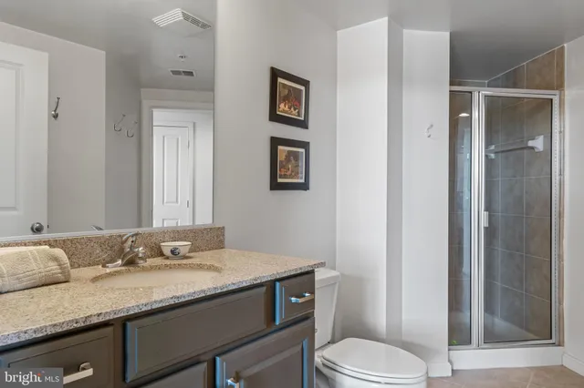 a bathroom with a granite countertop sink toilet and shower