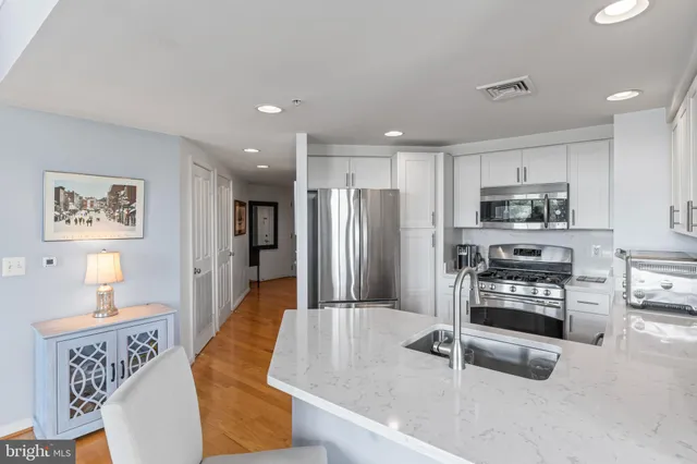 a kitchen with stainless steel appliances granite countertop a refrigerator and a stove top oven