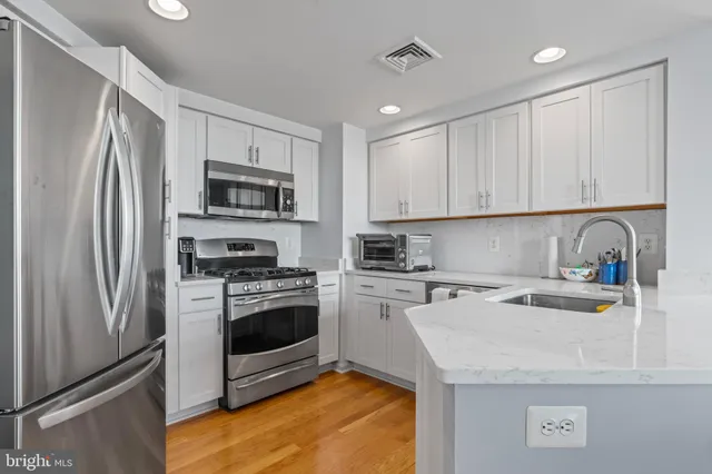 a kitchen with a sink a stove a refrigerator and cabinets