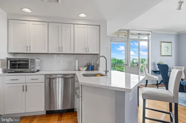a kitchen with a stove a sink and white cabinets
