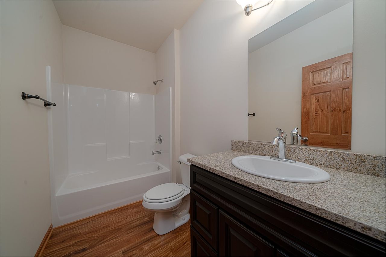9909 Lismore Road Roscoe, IL 61073 - Photo 19 of 24 a bathroom with a granite countertop toilet sink and mirror