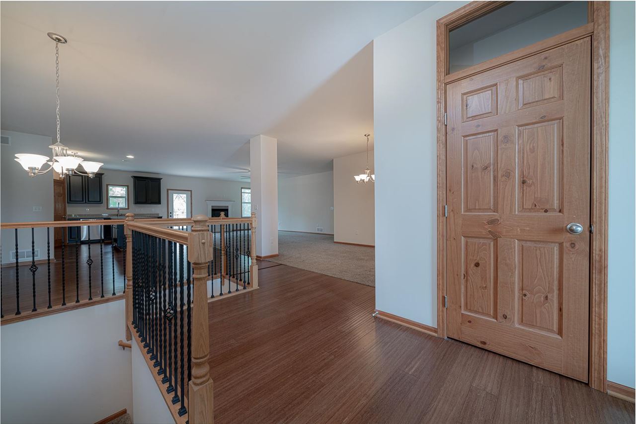9909 Lismore Road Roscoe, IL 61073 - Photo 4 of 24 a view of a hallway with wooden floor and seating area