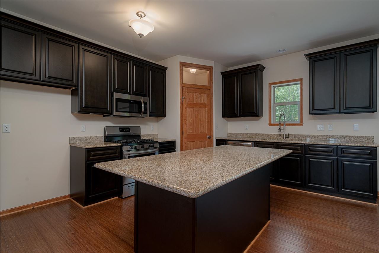 9909 Lismore Road Roscoe, IL 61073 - Photo 9 of 24 a kitchen with a sink cabinets and wooden floor
