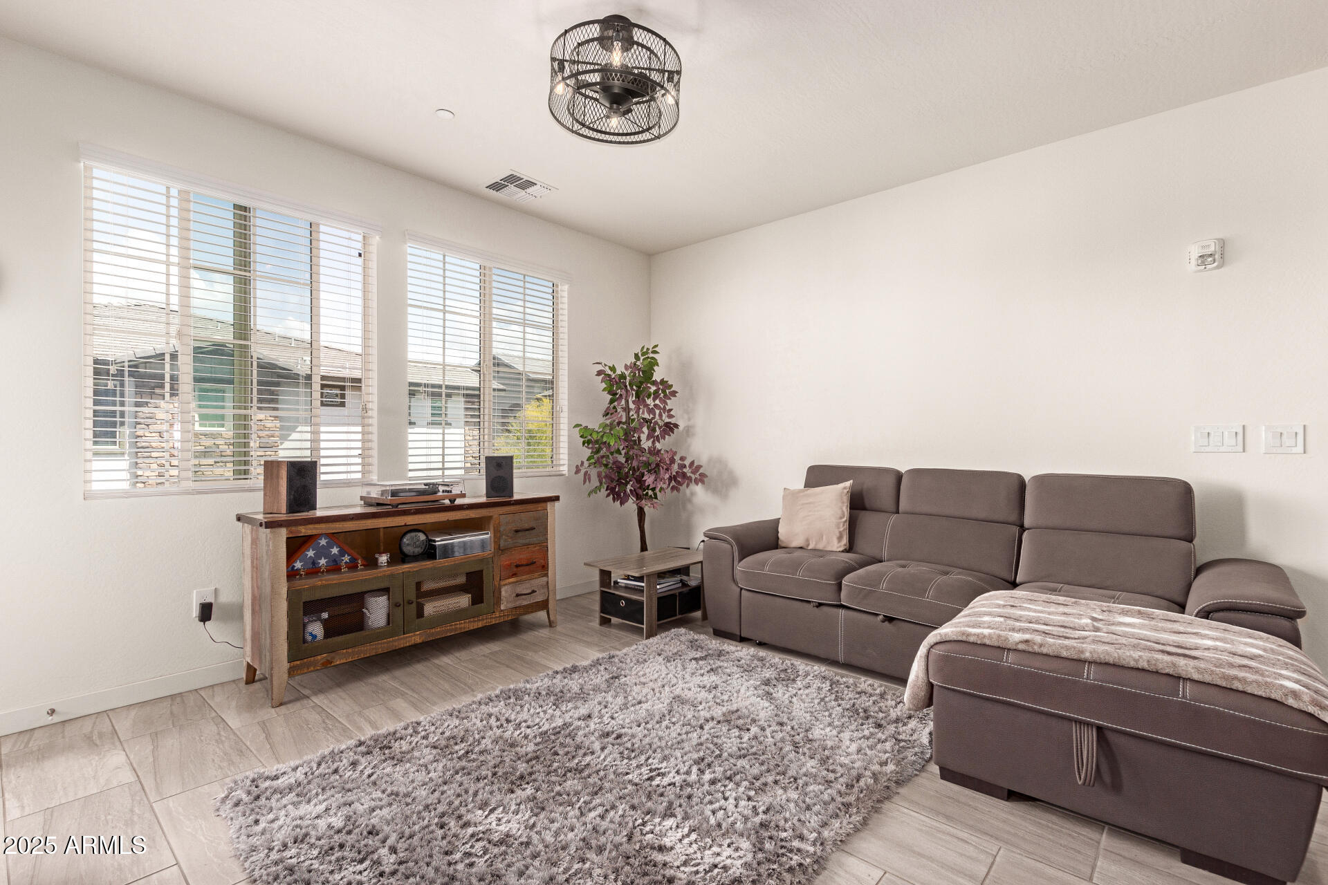 1851 East Frye Road, Unit 101 Gilbert, AZ 85295 - Photo 7 of 37 a living room with furniture a bed and a chandelier