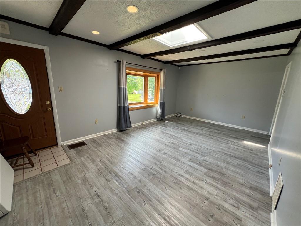 203 Carson Street Springdale, PA 15144 - Photo 5 of 43 an empty room with wooden floor mirror and windows