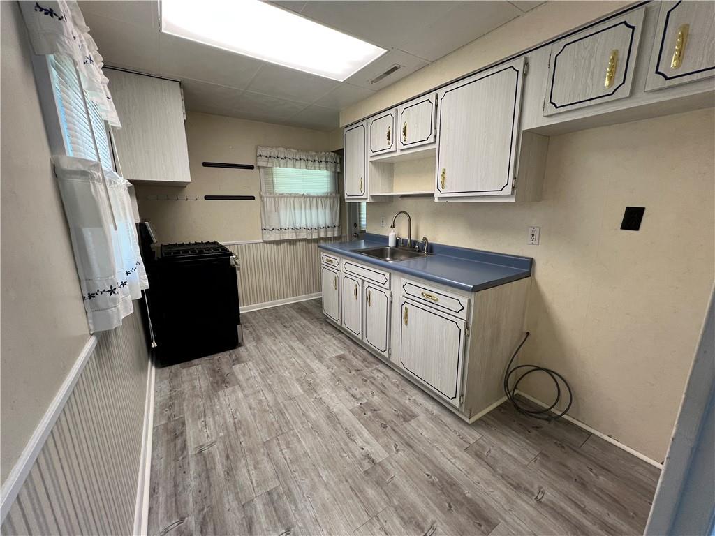 203 Carson Street Springdale, PA 15144 - Photo 8 of 43 a kitchen with stainless steel appliances granite countertop a refrigerator a stove a sink and white cabinets with wooden floor