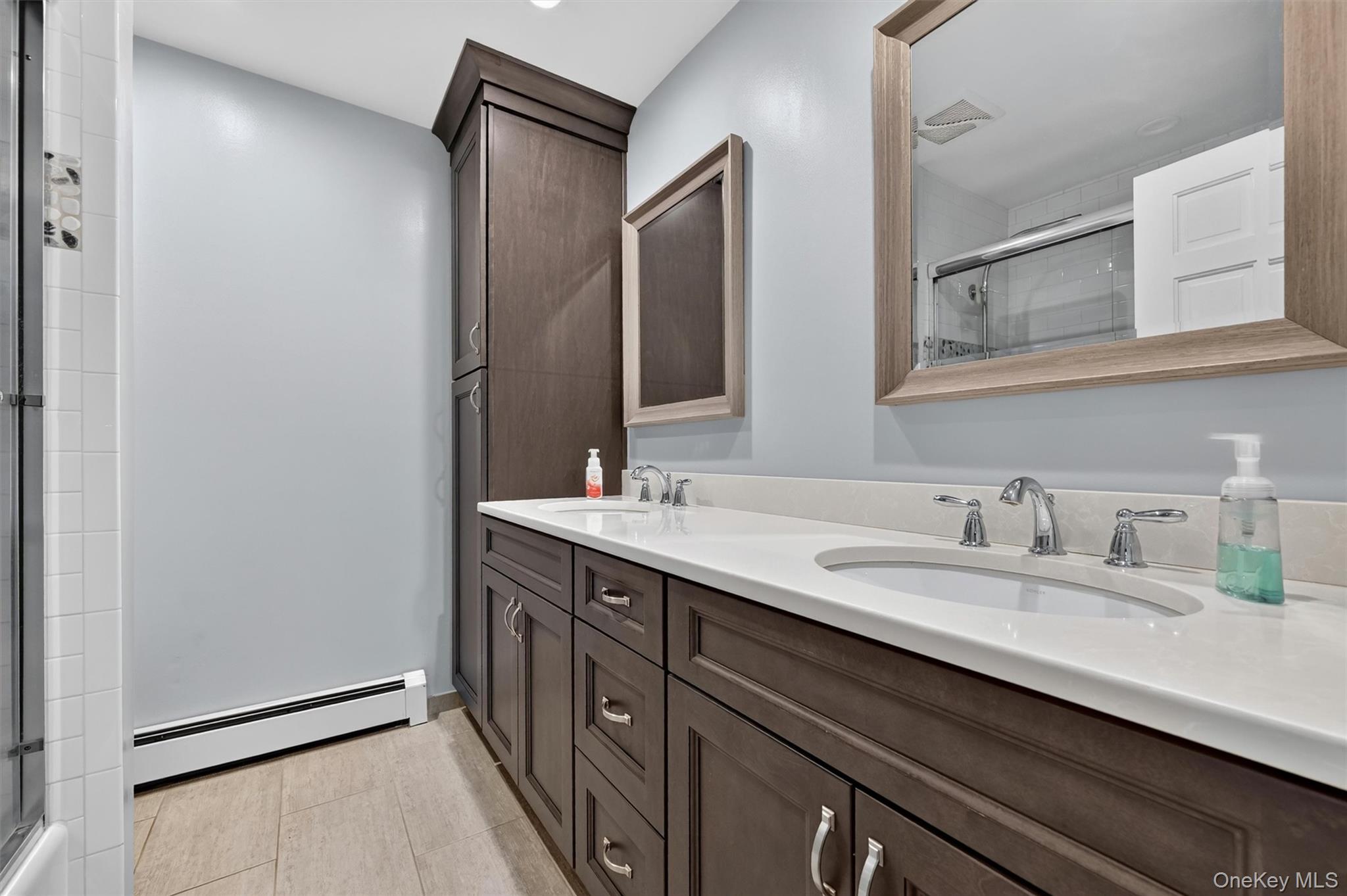 5 Hedges Road Warwick, NY 10990 - Photo 35 of 48 The updated hall bath features dual sinks, modern cabinetry, neutral finishes, and a clean, functional layout.