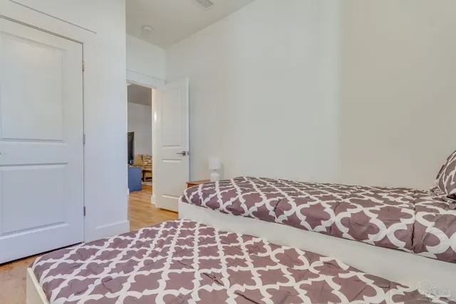 a bedroom with a bed and a wooden floor