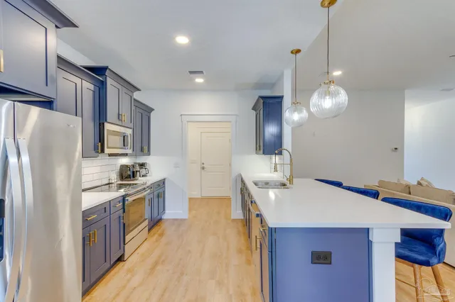 a kitchen with stainless steel appliances a sink stove and refrigerator
