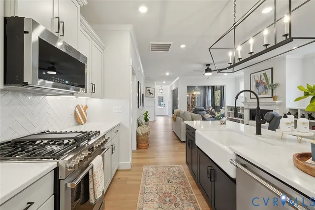 a large kitchen with stainless steel appliances granite countertop a lot of counter space and a sink
