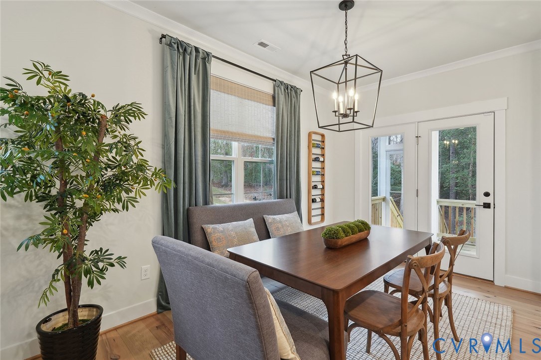 8711 Terroir Lane New Kent, VA 23124 - Photo 6 of 27 a view of a dining room with furniture window and wooden floor